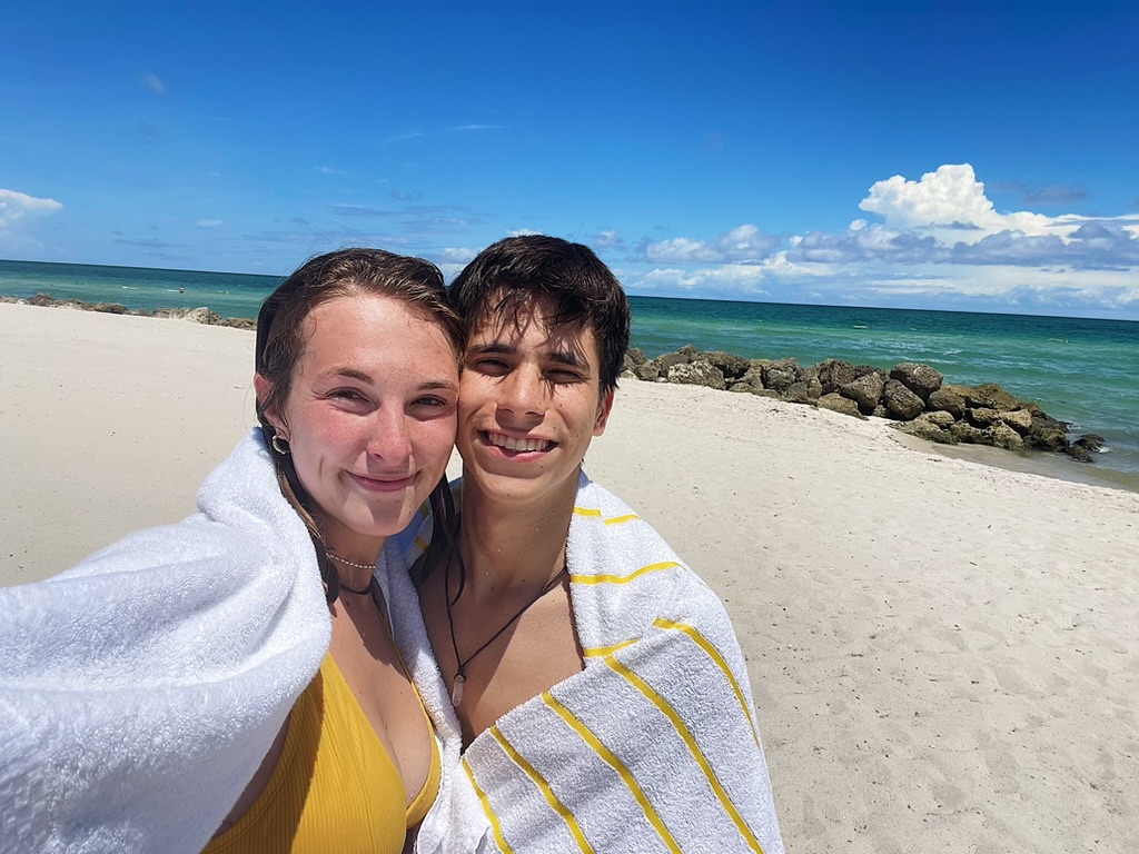 Jade and Juan wrapped in towels together on the beach