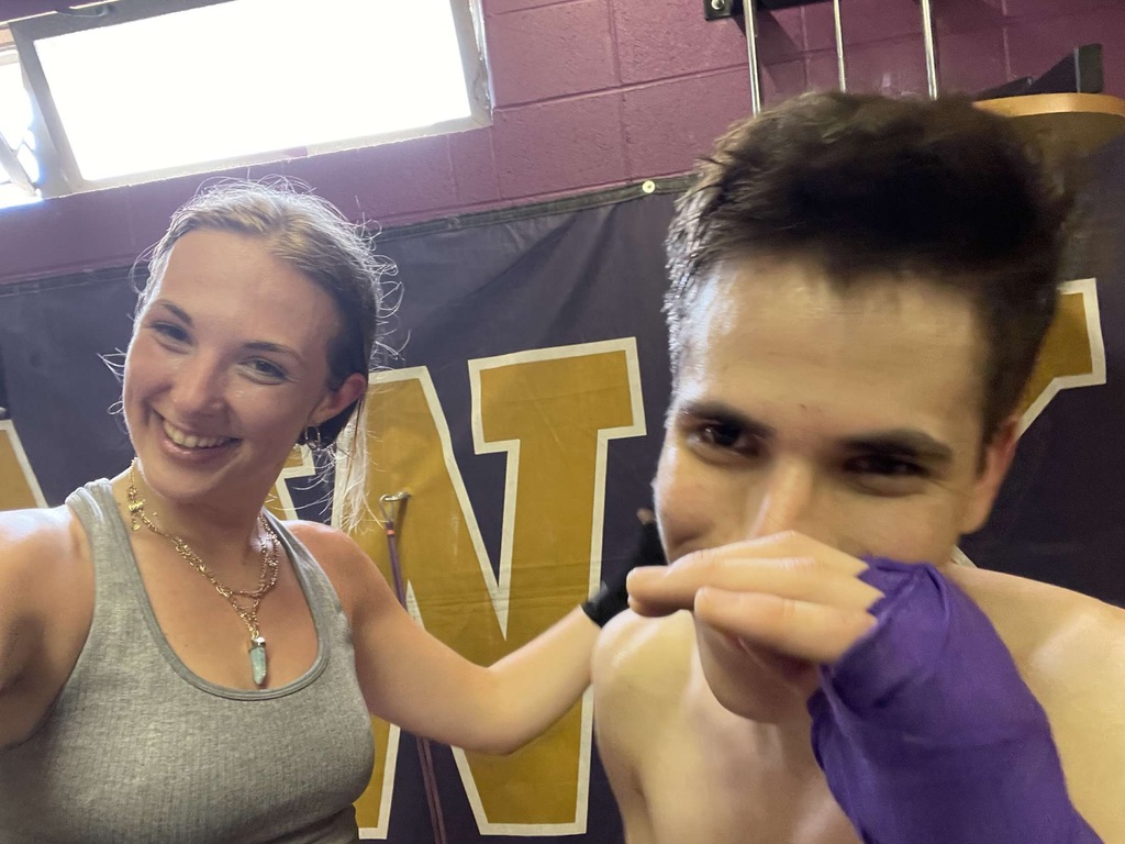 Jade and Juan smiling together at a boxing gym