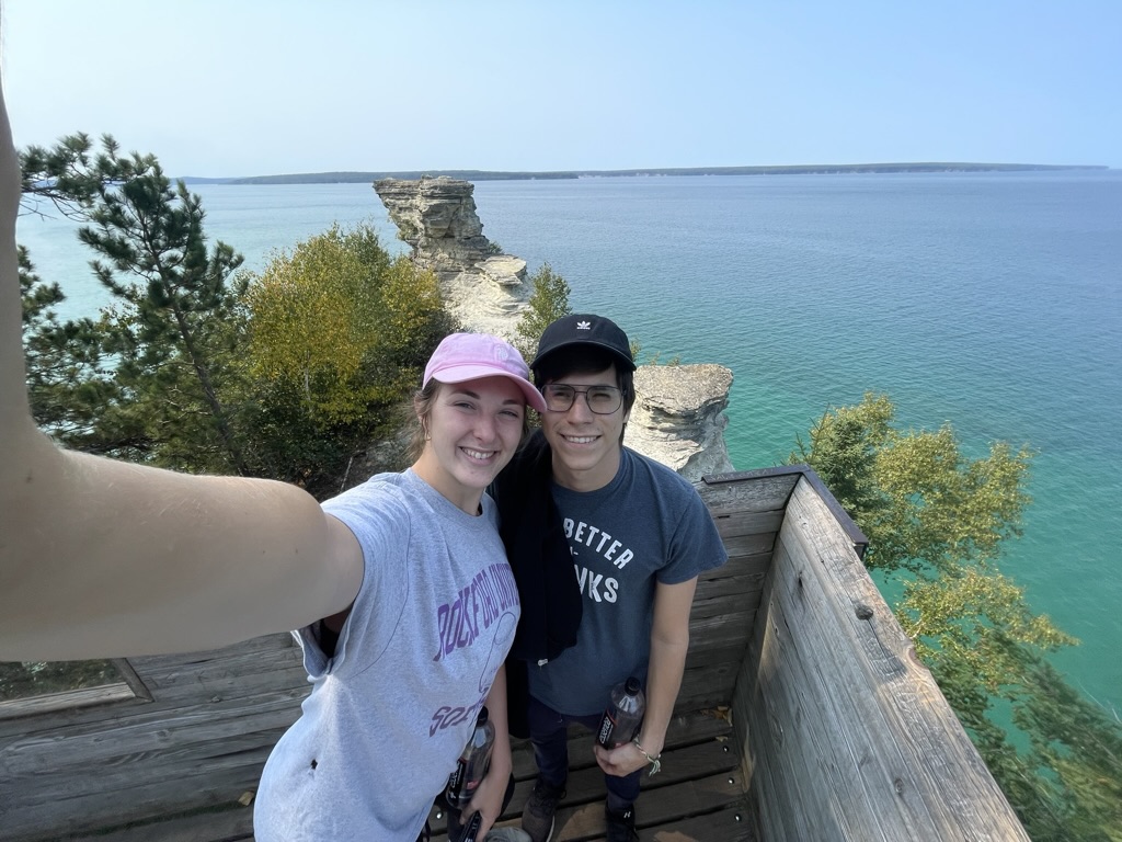 Jade and Juan smiling at a turquoise lakeshore overlook