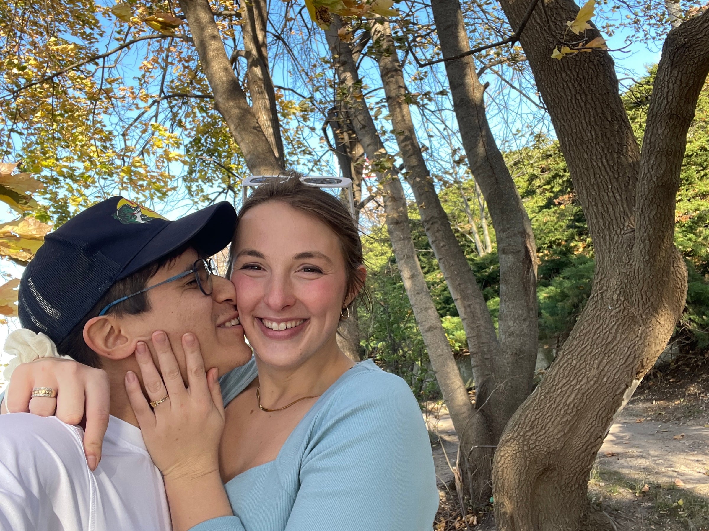 Jade and Juan sharing a kiss by the lake