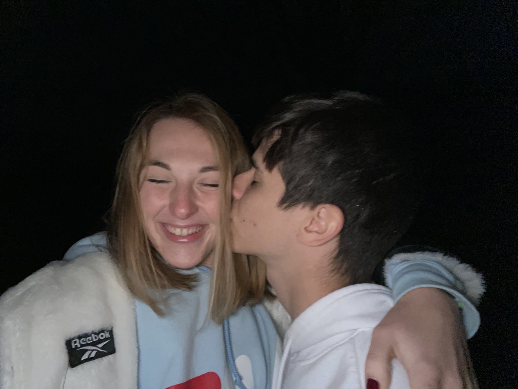 Juan kissing Jade on the cheek at night