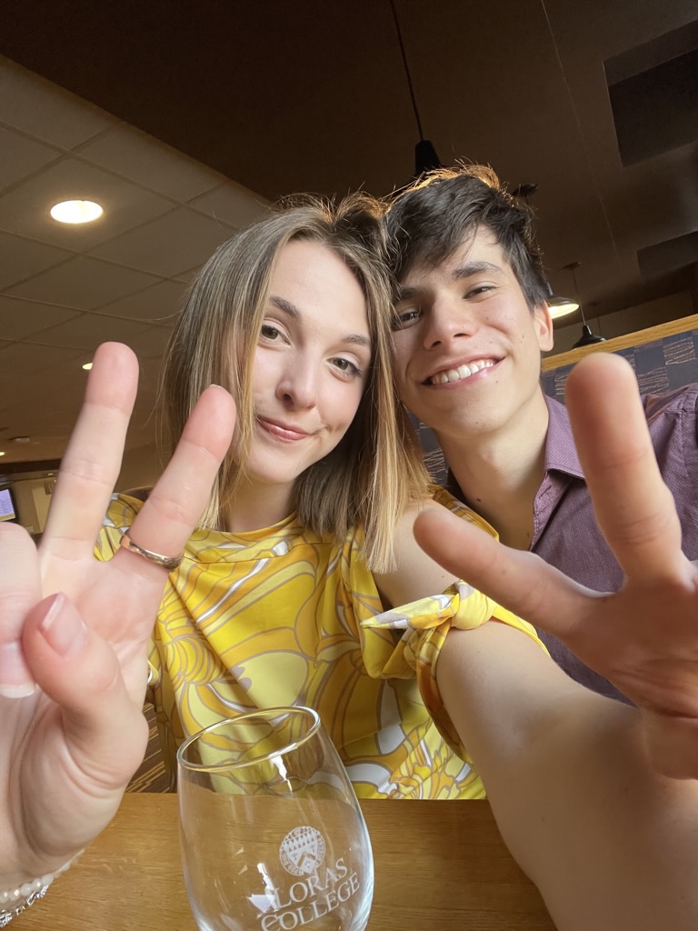 Jade and Juan holding up peace signs during a date