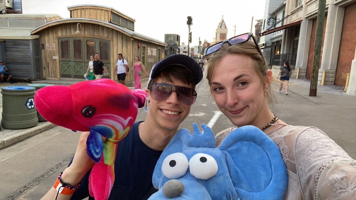 Jade and Juan posing with colorful carnival prizes