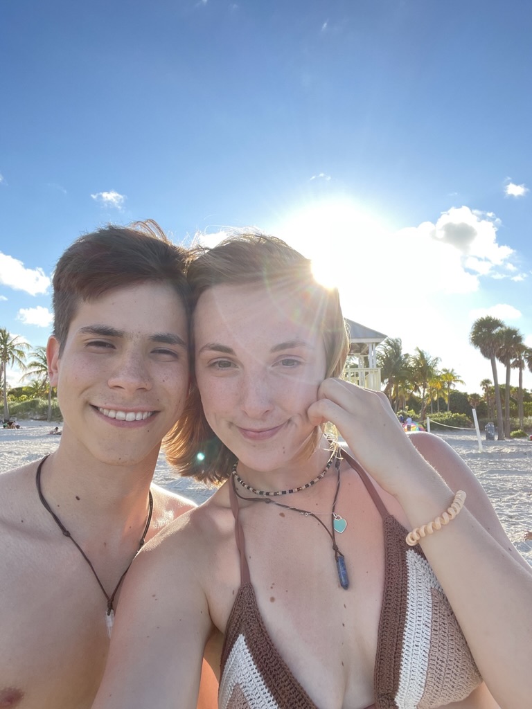 Jade and Juan taking a sunlit beach selfie