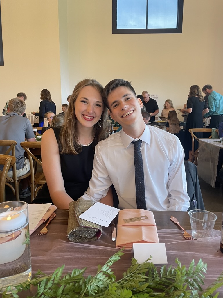 Jade and Juan smiling together at a wedding reception